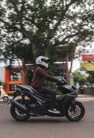 a man riding a motorcycle down a street