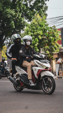 a couple of people riding on the back of a motorcycle