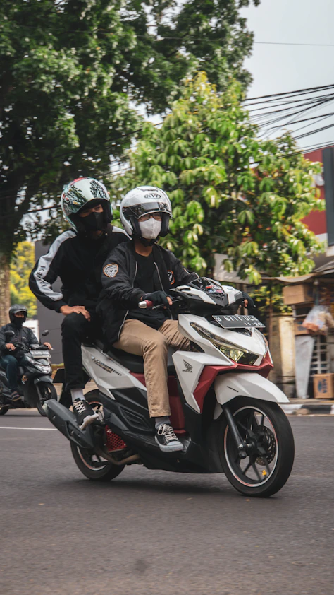 a couple of people riding on the back of a motorcycle