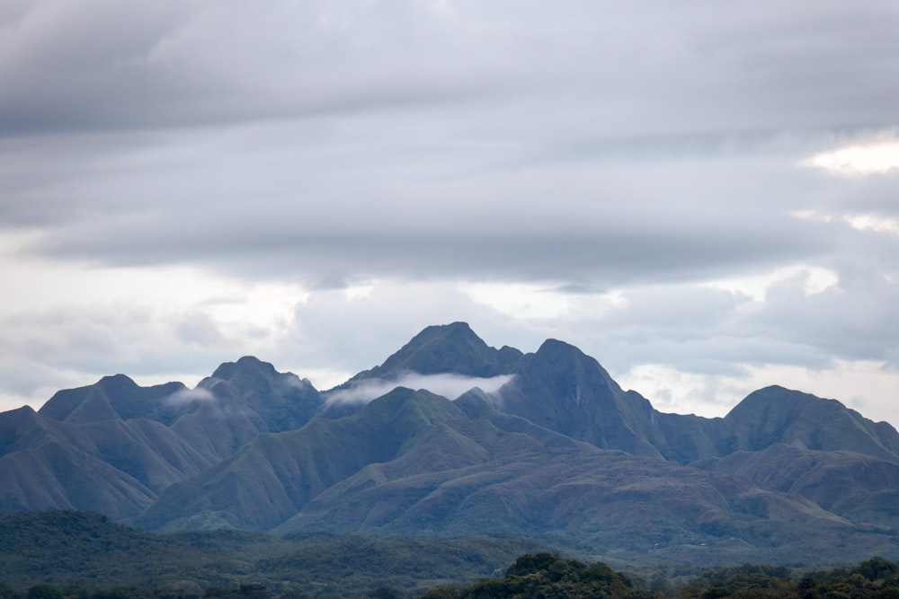 a mountain range with a few clouds in the sky