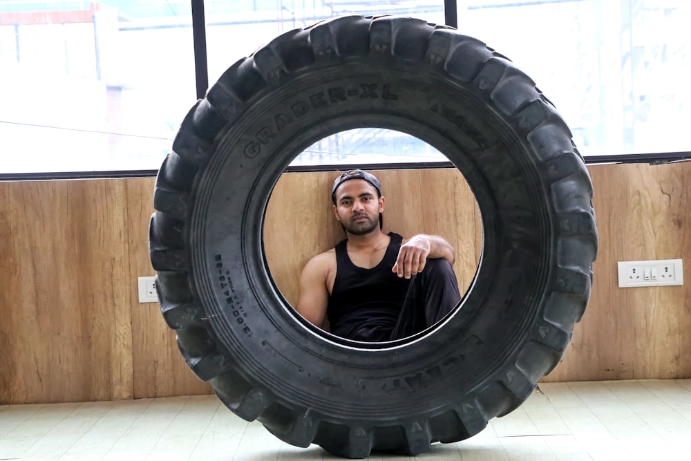 a man sitting inside of a giant tire