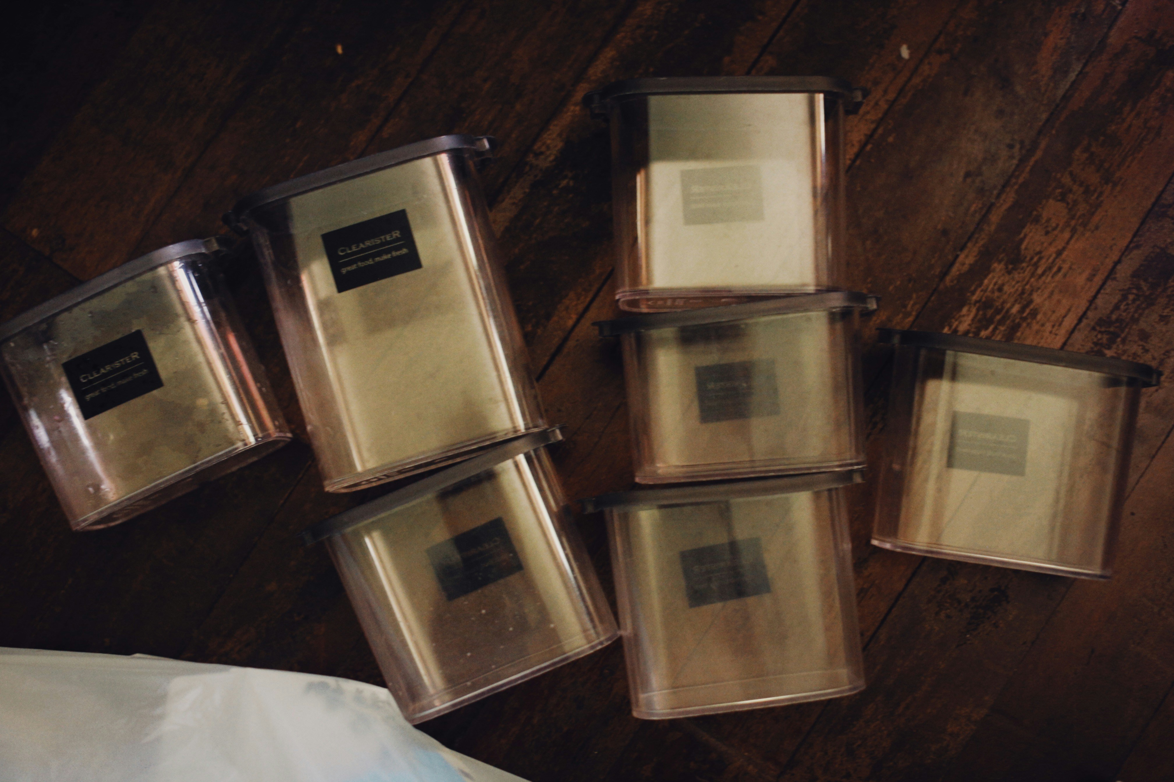 a pile of plastic containers sitting on top of a wooden floor