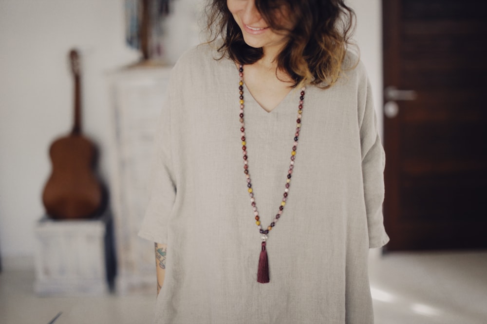 a woman wearing a necklace with a tassel