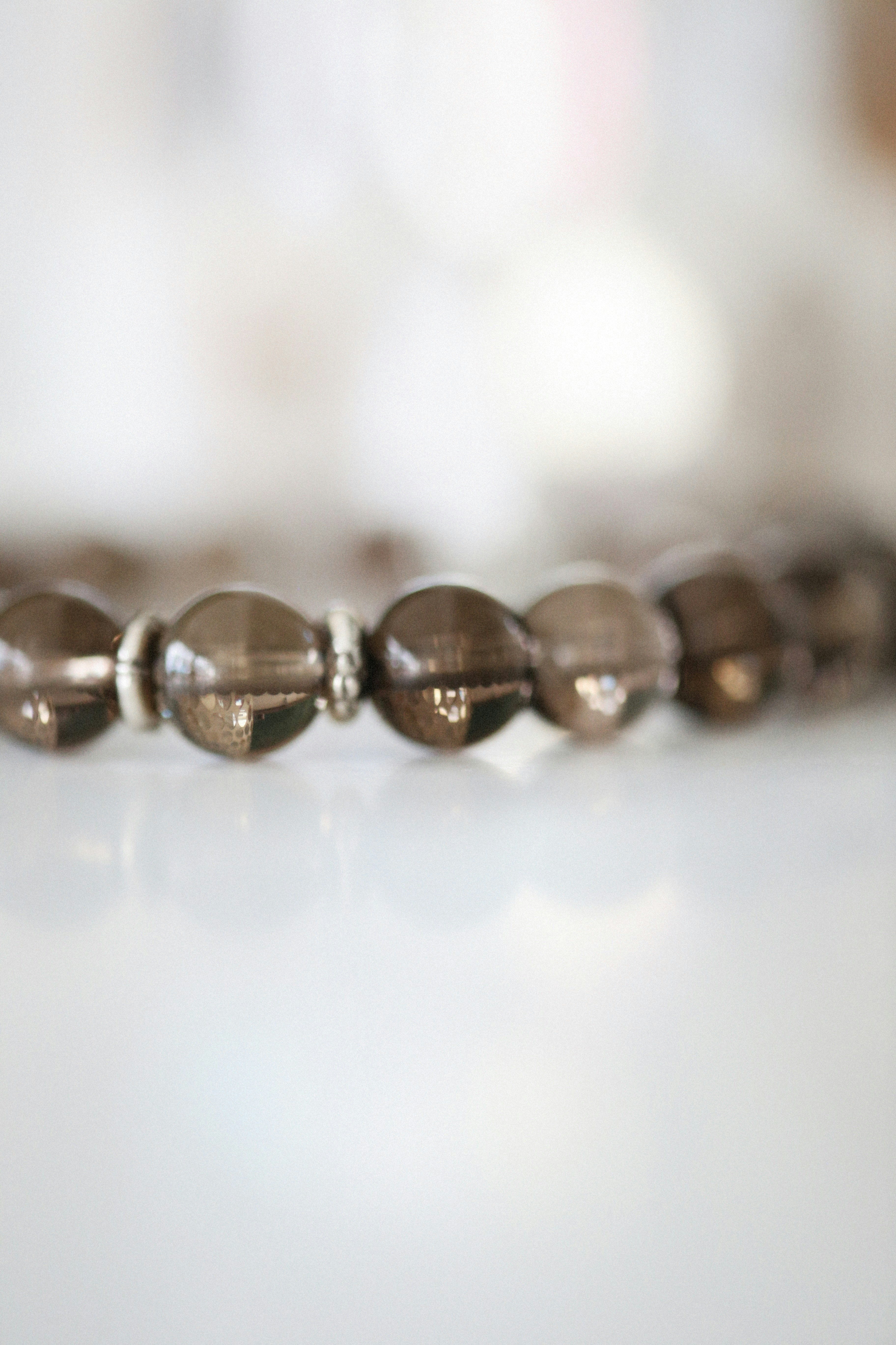White crystal quartz bead bracelet with gold spacers on white background
