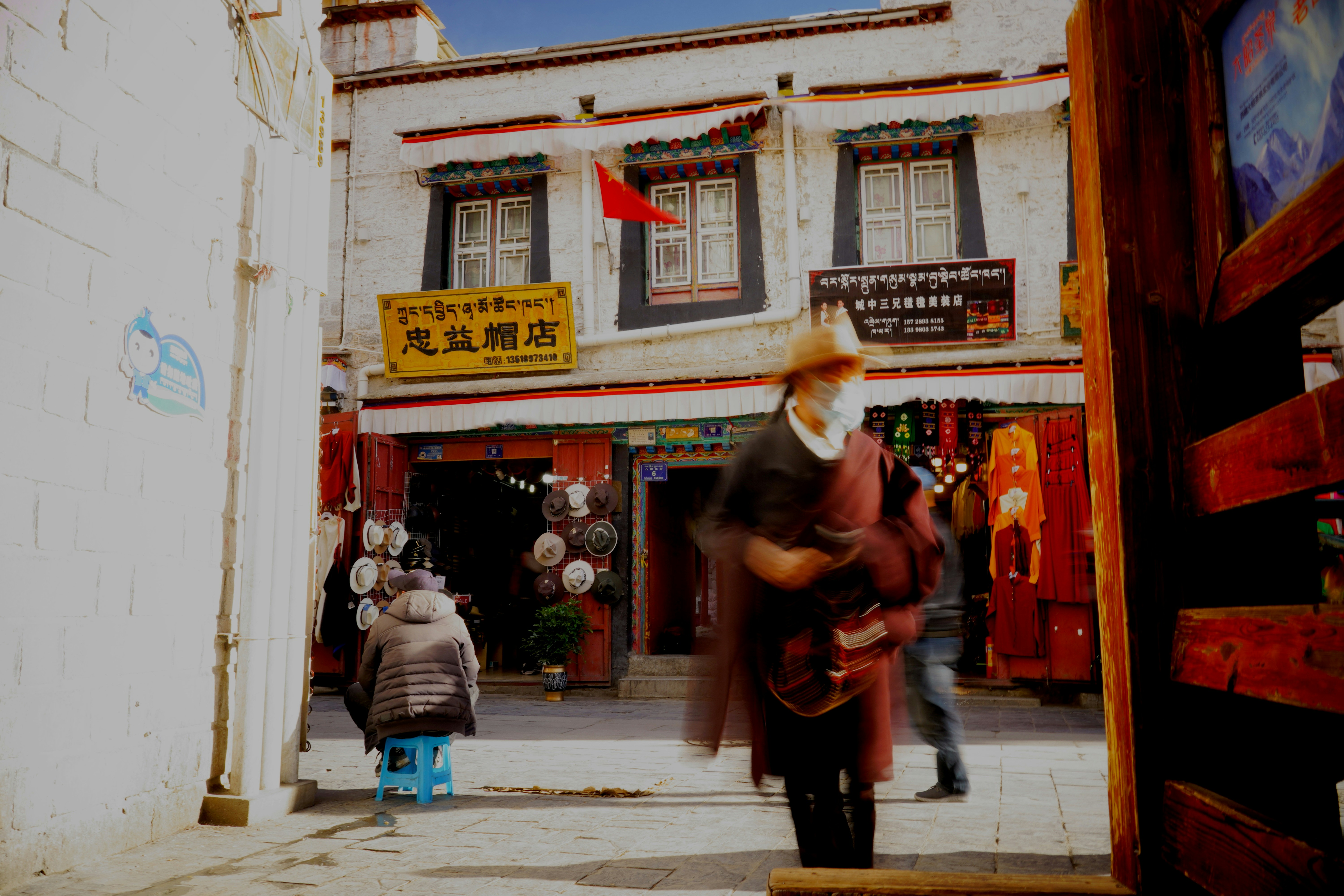 a man walking down a street next to a tall building