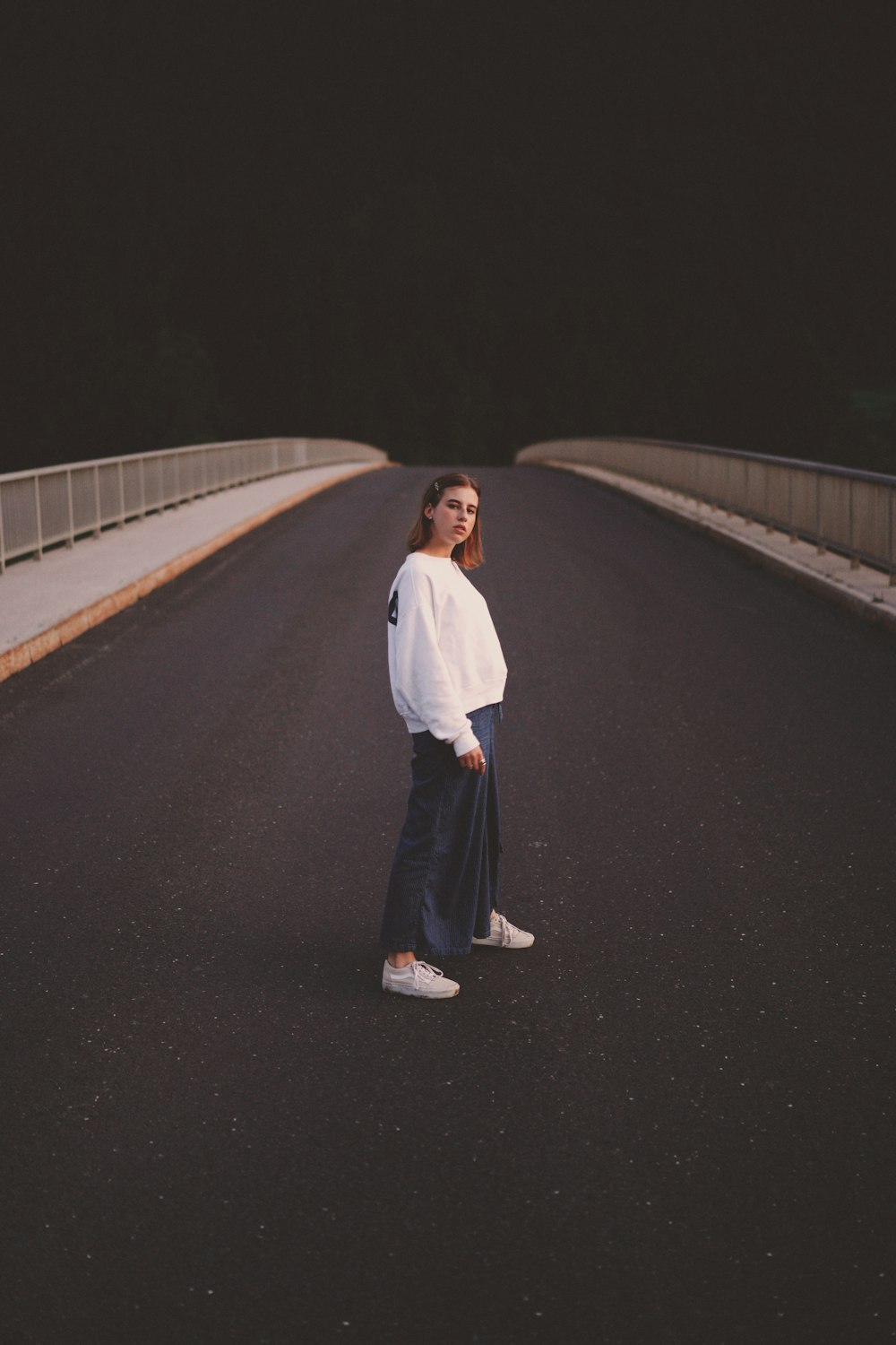 a woman standing in the middle of a road