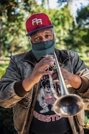 a man in a red hat is playing a trumpet