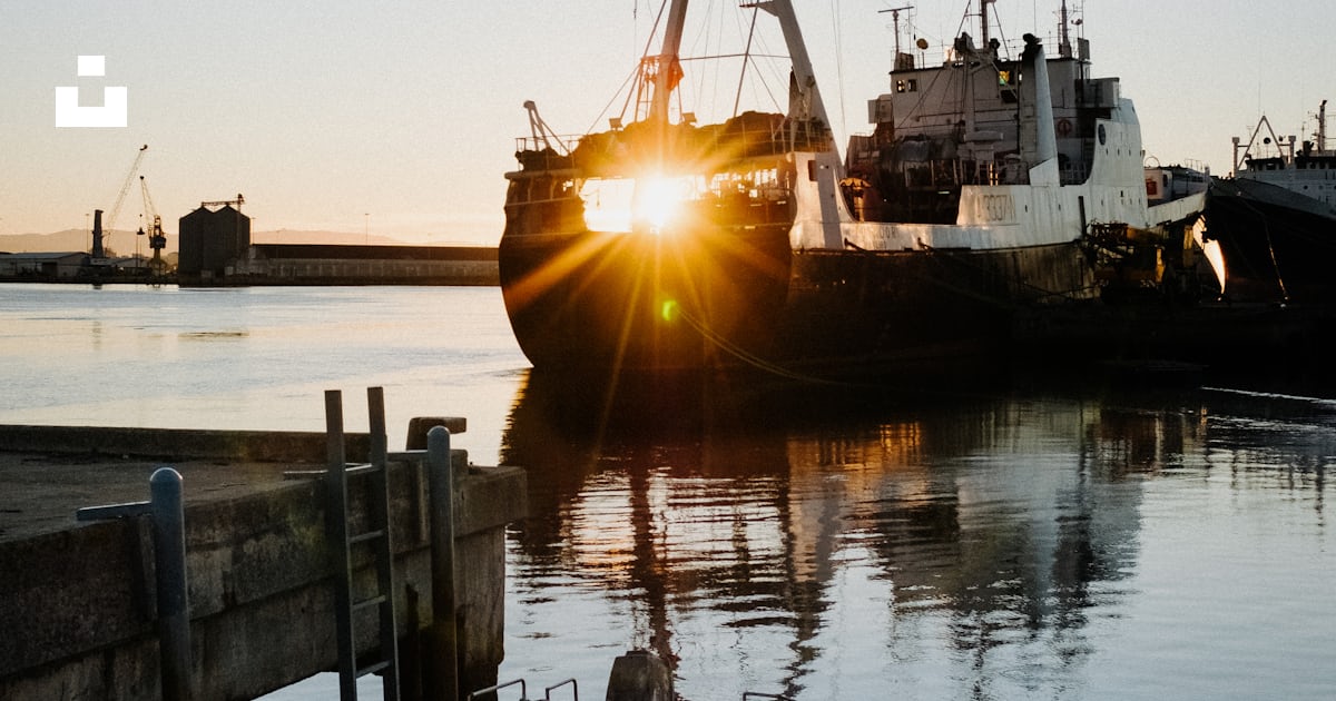 Foto zum Thema Ein kleines Boot sitzt im Wasser neben einem Dock