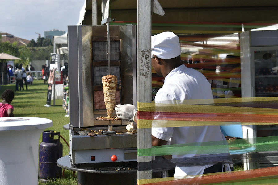 African chef cooking over a grill at a community food event