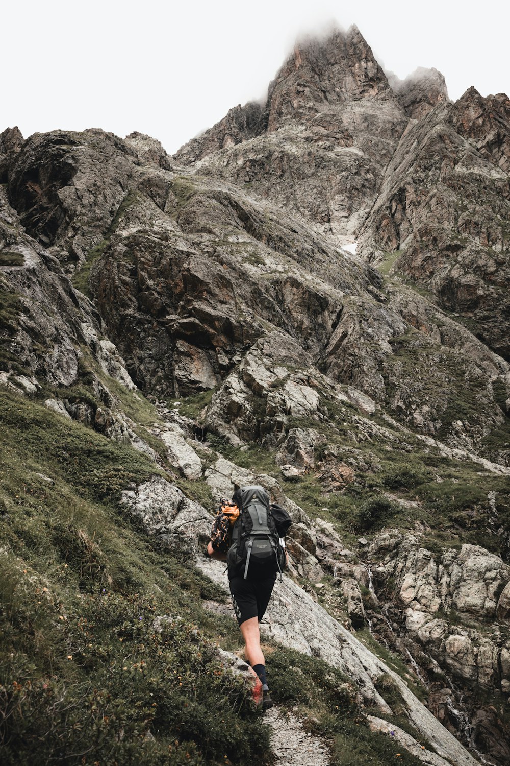 a man hiking up a mountain with a backpack