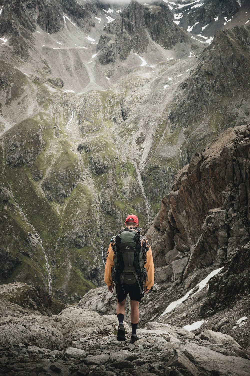 a man with a backpack walking up a mountain