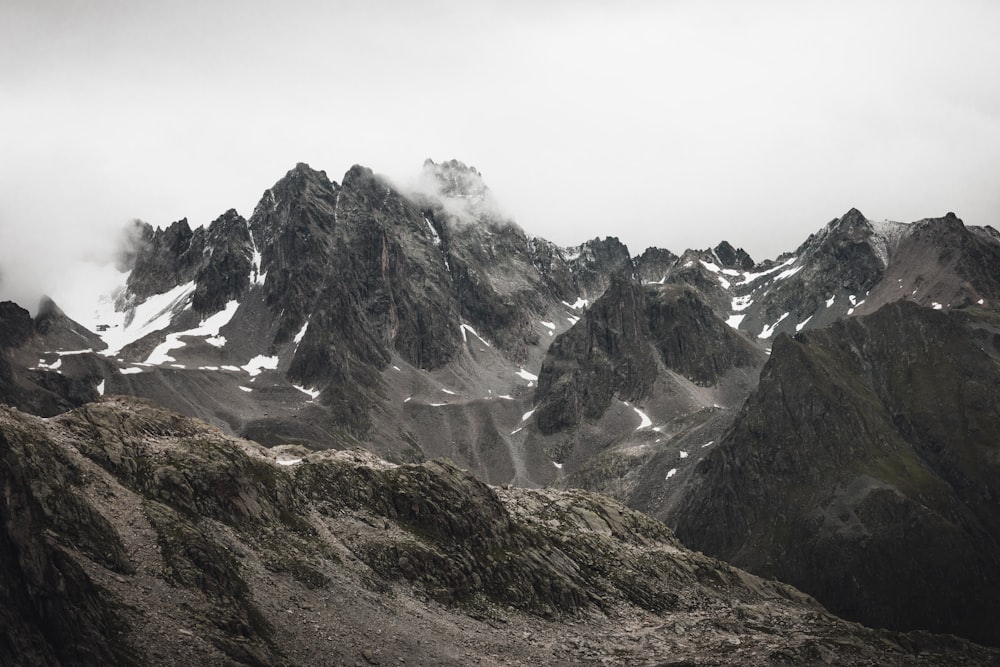 a mountain range covered in snow and clouds