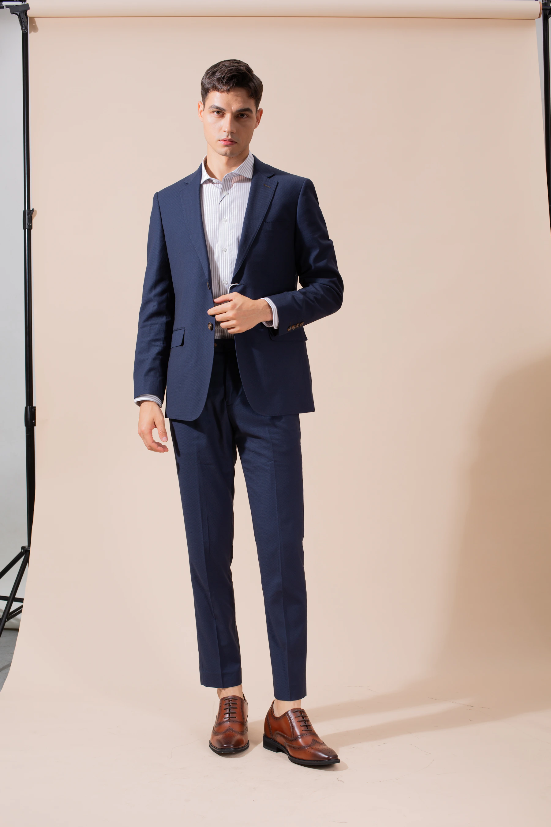 Man in a navy suit showing a clean tailored trouser line
