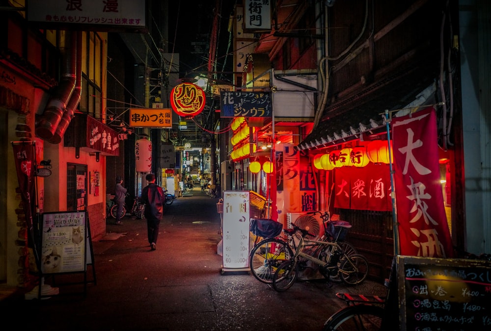 a man walking down a street at night