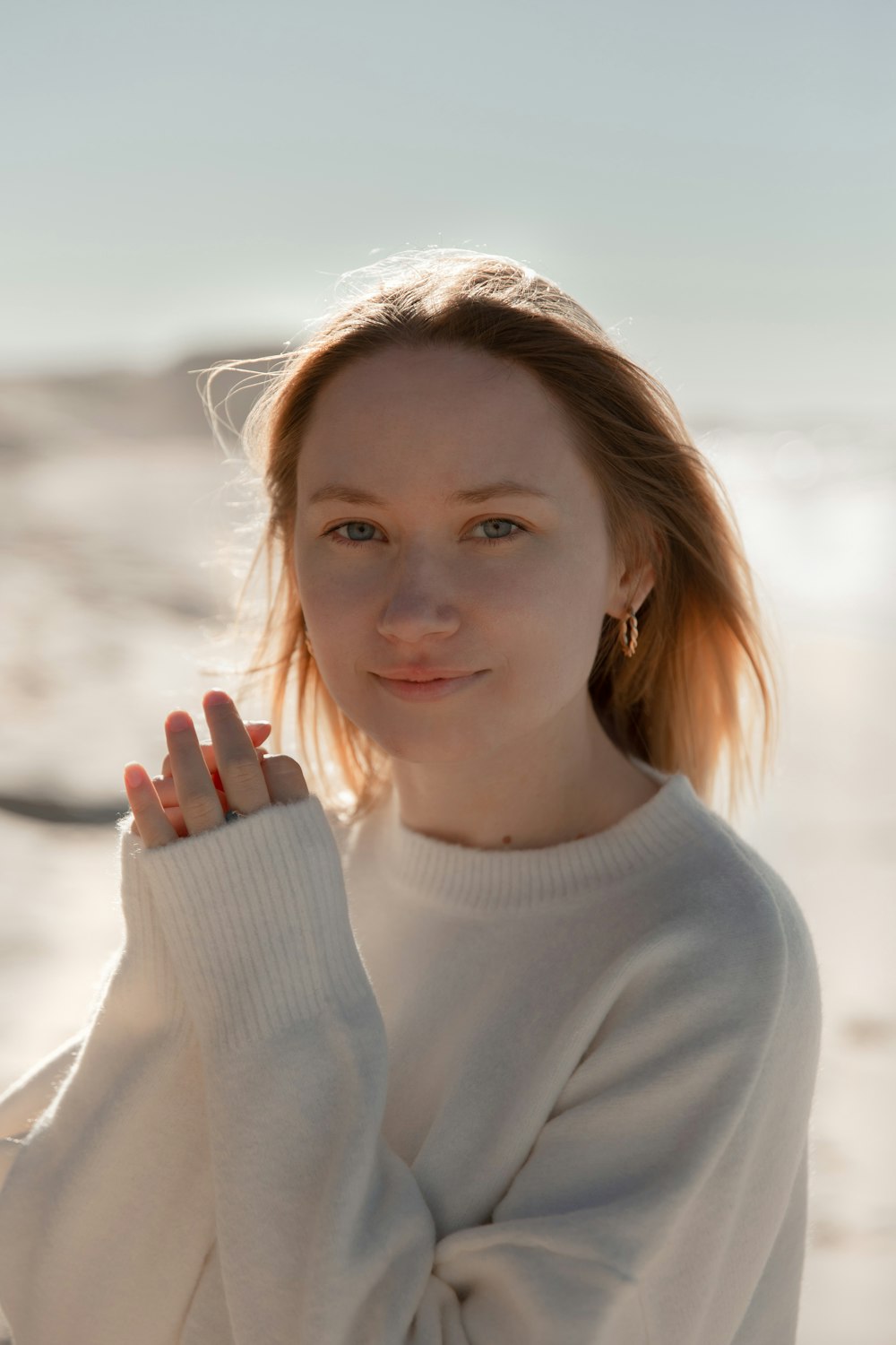 a woman standing on a beach with her hand on her hip