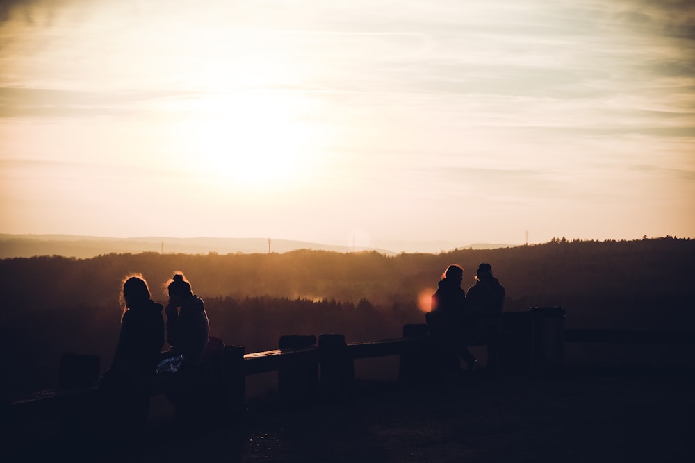 a group of people sitting on top of a wooden bench