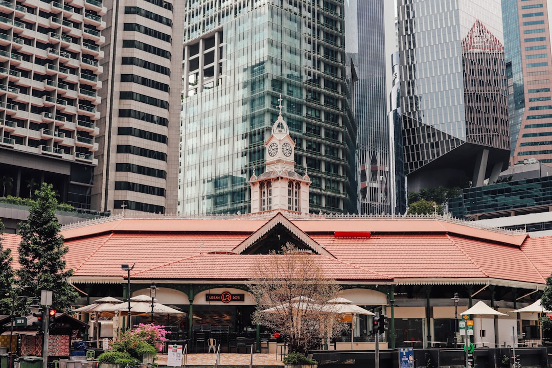 a building with a clock tower in the middle of a city, Lau Pa Sat Market in the day. Photo by SGXP.com