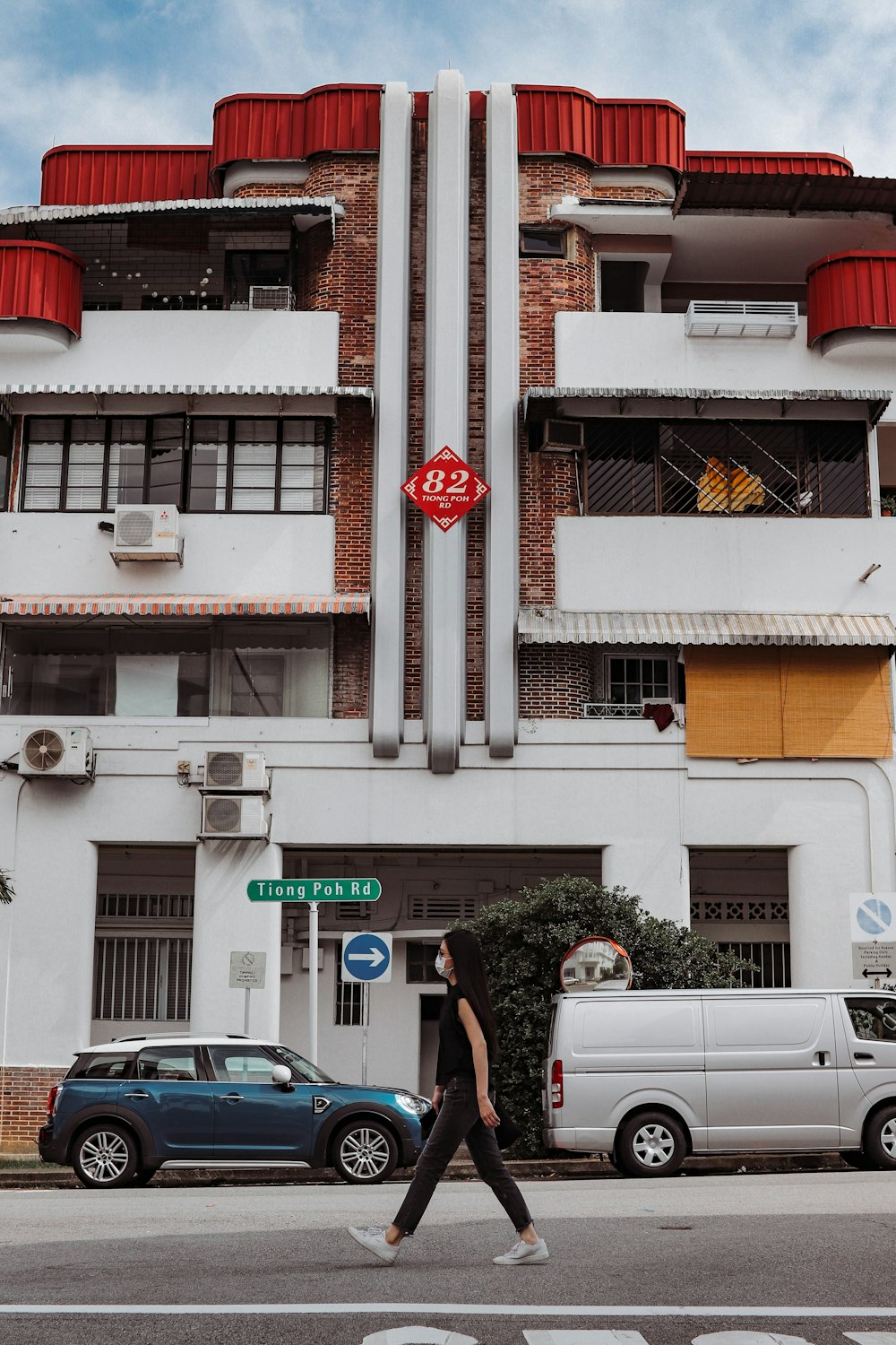 a woman crossing the street in front of a building