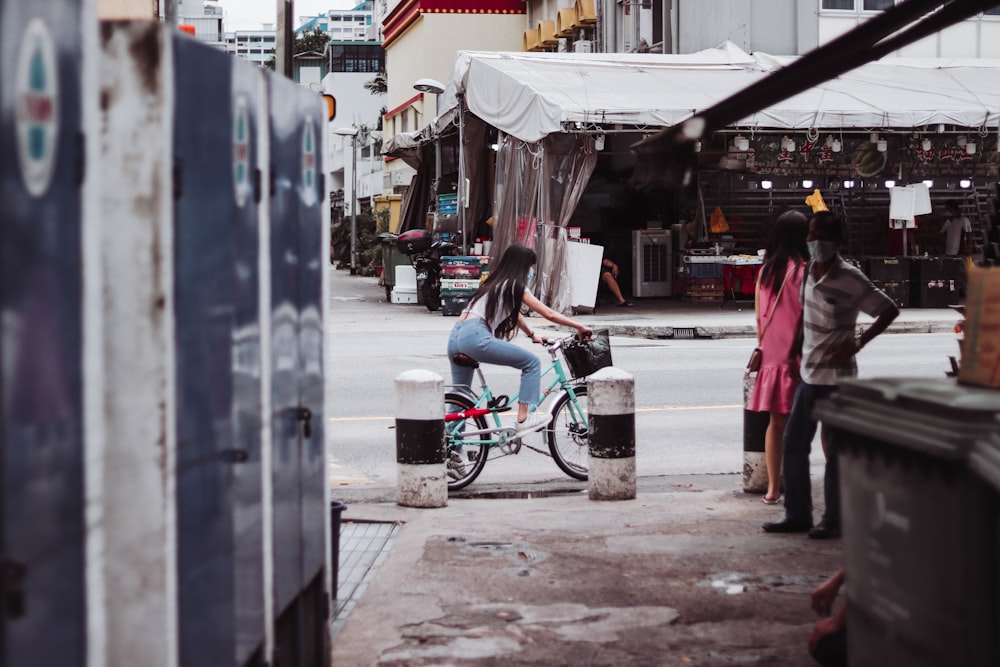 a woman riding a bike down a street