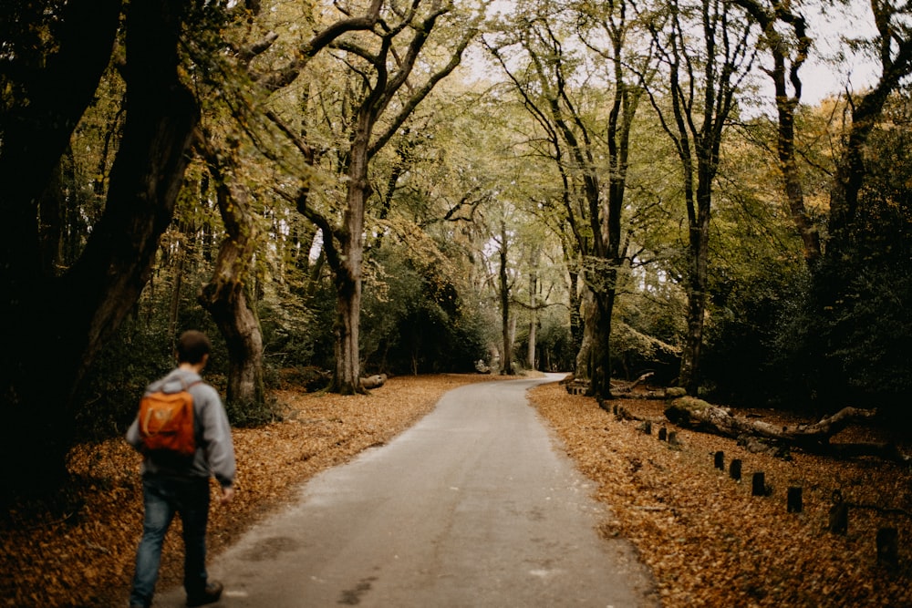 Un uomo con uno zaino in spalla che cammina lungo un sentiero nel bosco