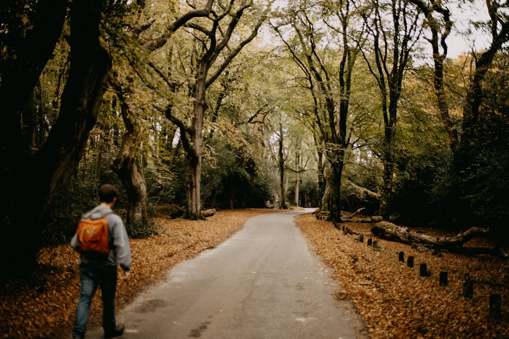 a man with a backpack walking down a path in the woods