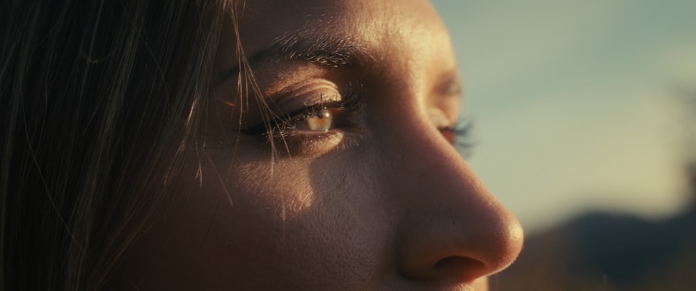 a close up of a woman's face with a building in the background