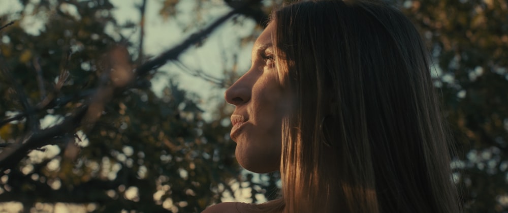 a woman standing in front of a tree