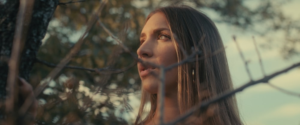 uma mulher em pé na frente de uma árvore