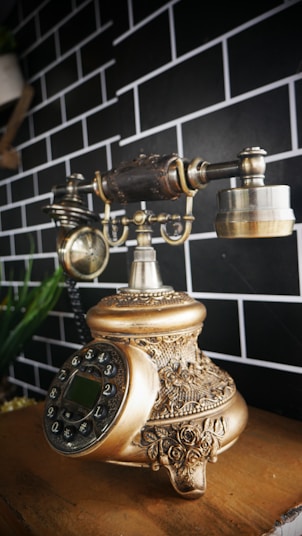 an old fashioned phone sitting on top of a wooden table