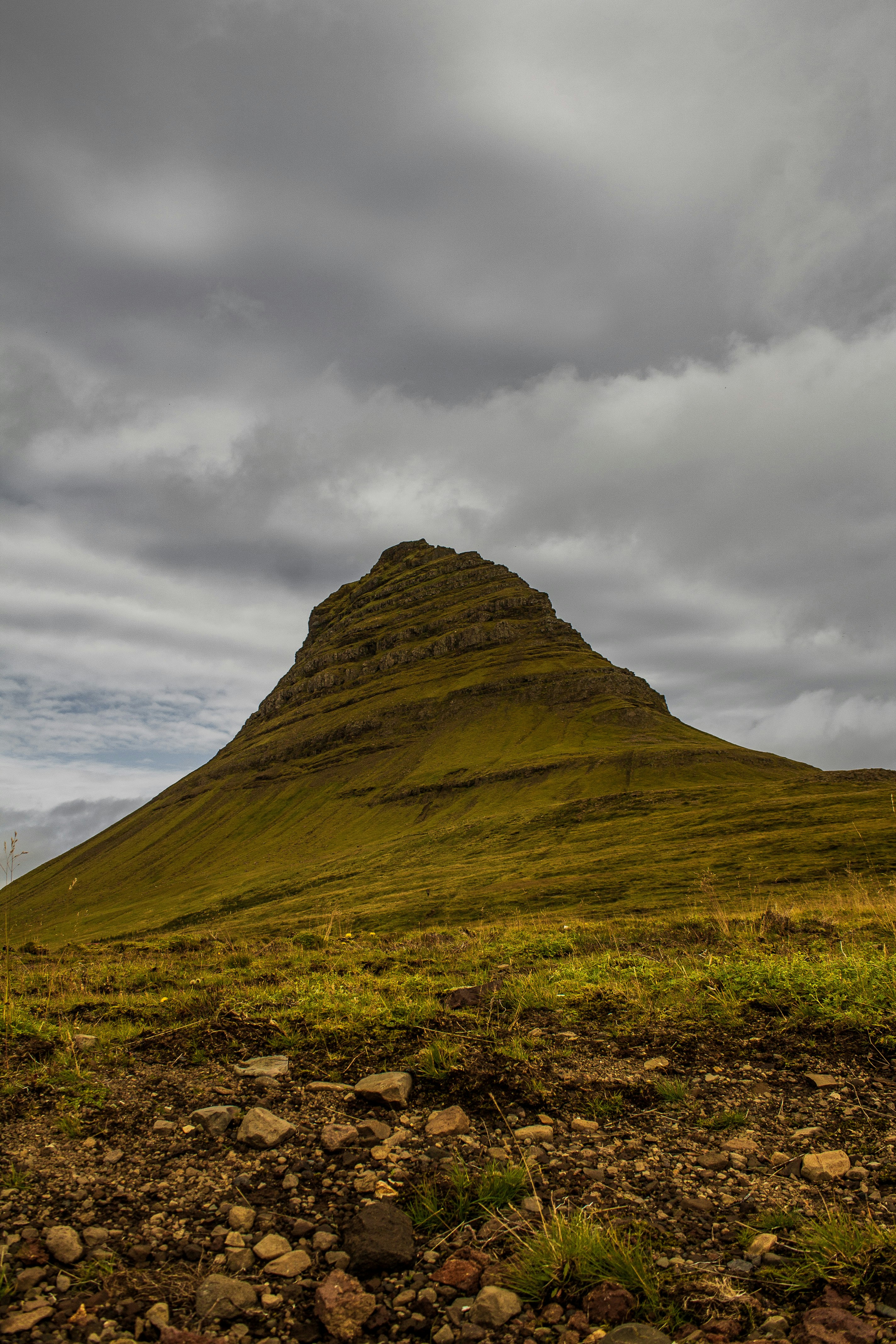 a grassy hill with rocks and grass in the foreground