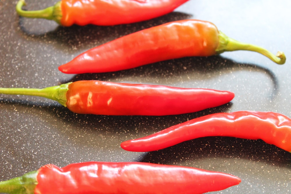 a group of red peppers sitting on top of a counter