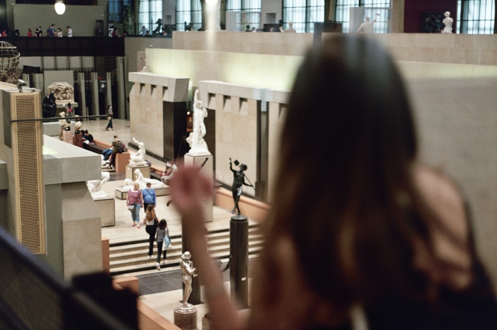 a woman standing in front of a statue in a museum