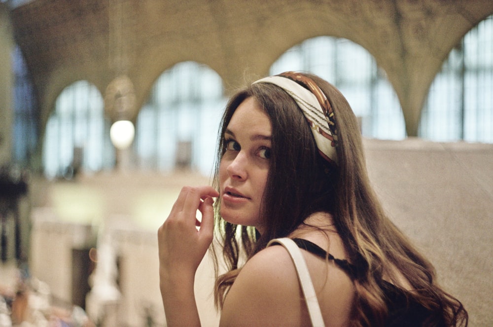 a woman with a headband on talking on a cell phone