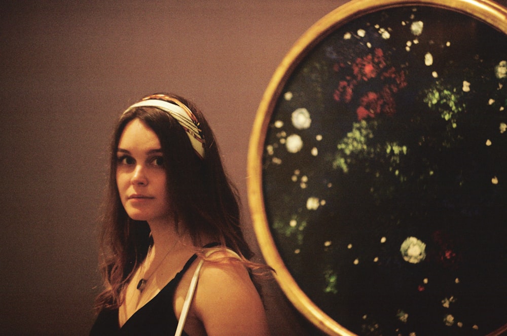 a woman standing in front of a large mirror