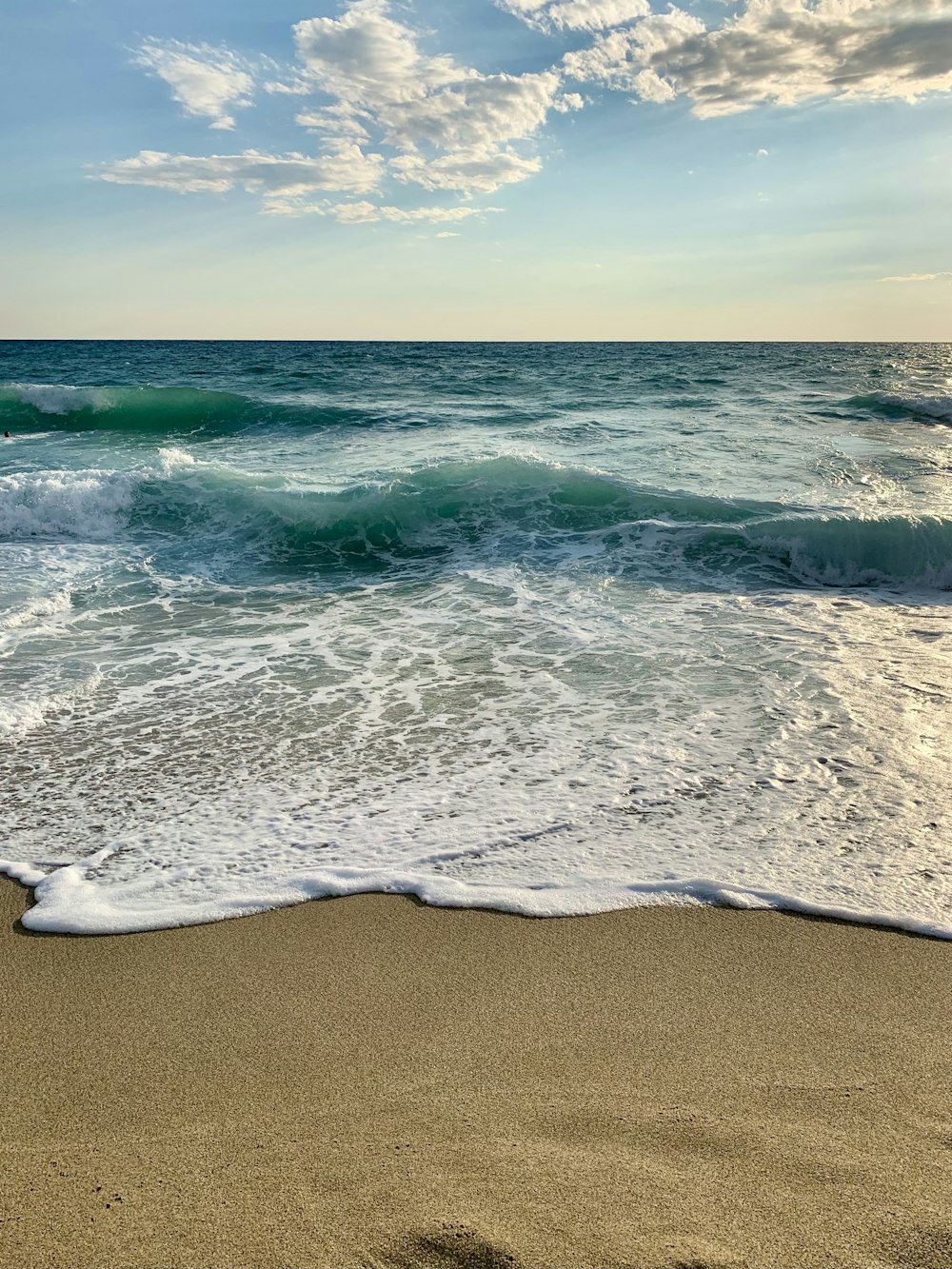 a sandy beach with waves coming in to shore