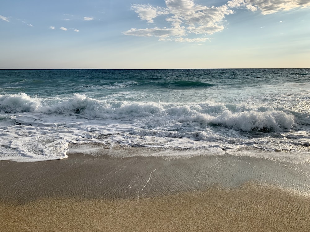 a sandy beach with waves coming in to shore