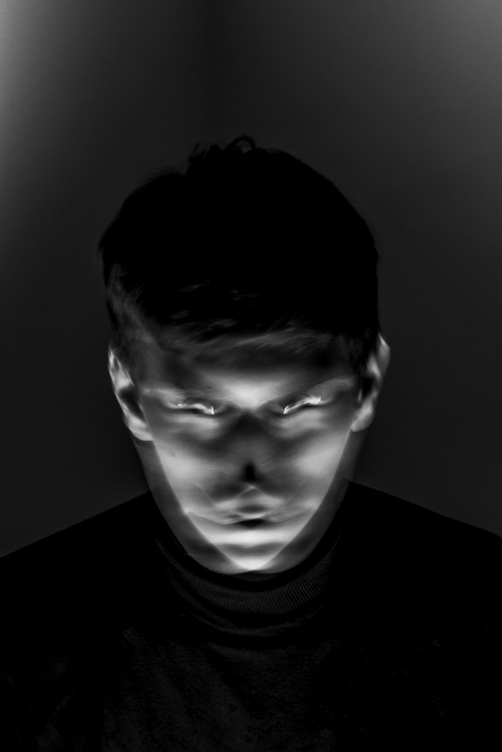um homem em um quarto escuro com os olhos brilhando