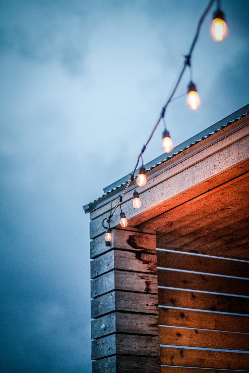 some lights are hanging from a roof of a building