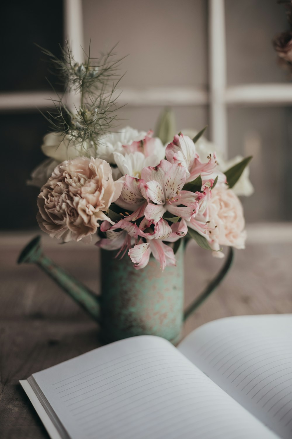a book and a vase with flowers on a table