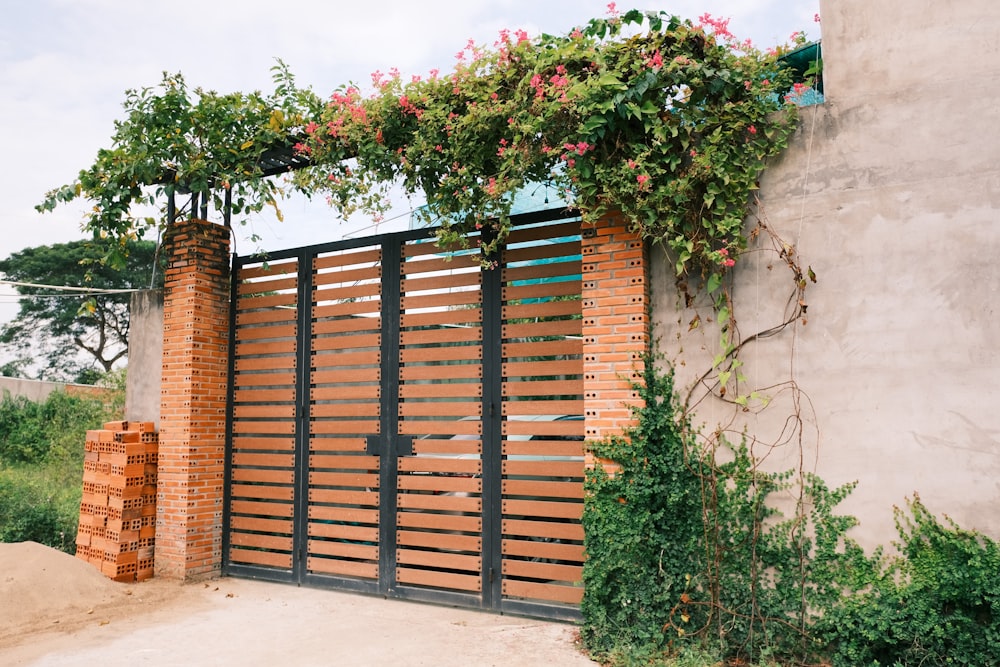 a wooden gate with flowers growing over it