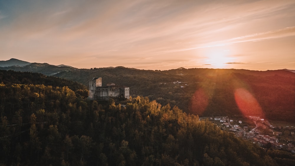 Il sole sta tramontando su una montagna con una torre