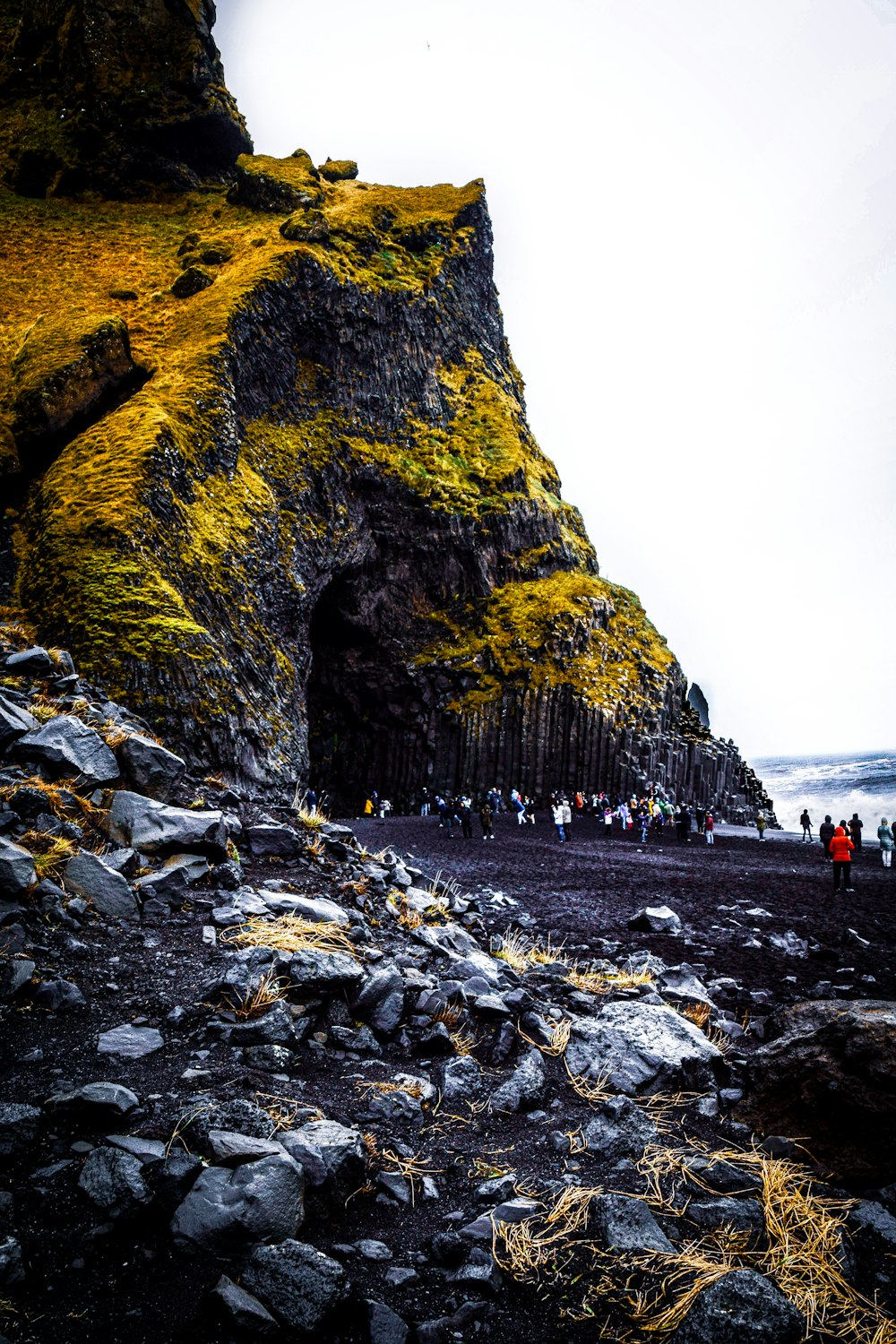 a group of people standing on top of a rocky beach