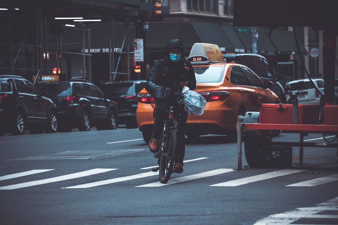 a man riding a bike down a street next to a traffic light, Ride Bike