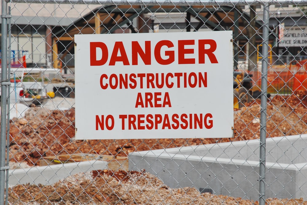 a construction area with a sign on a chain link fence