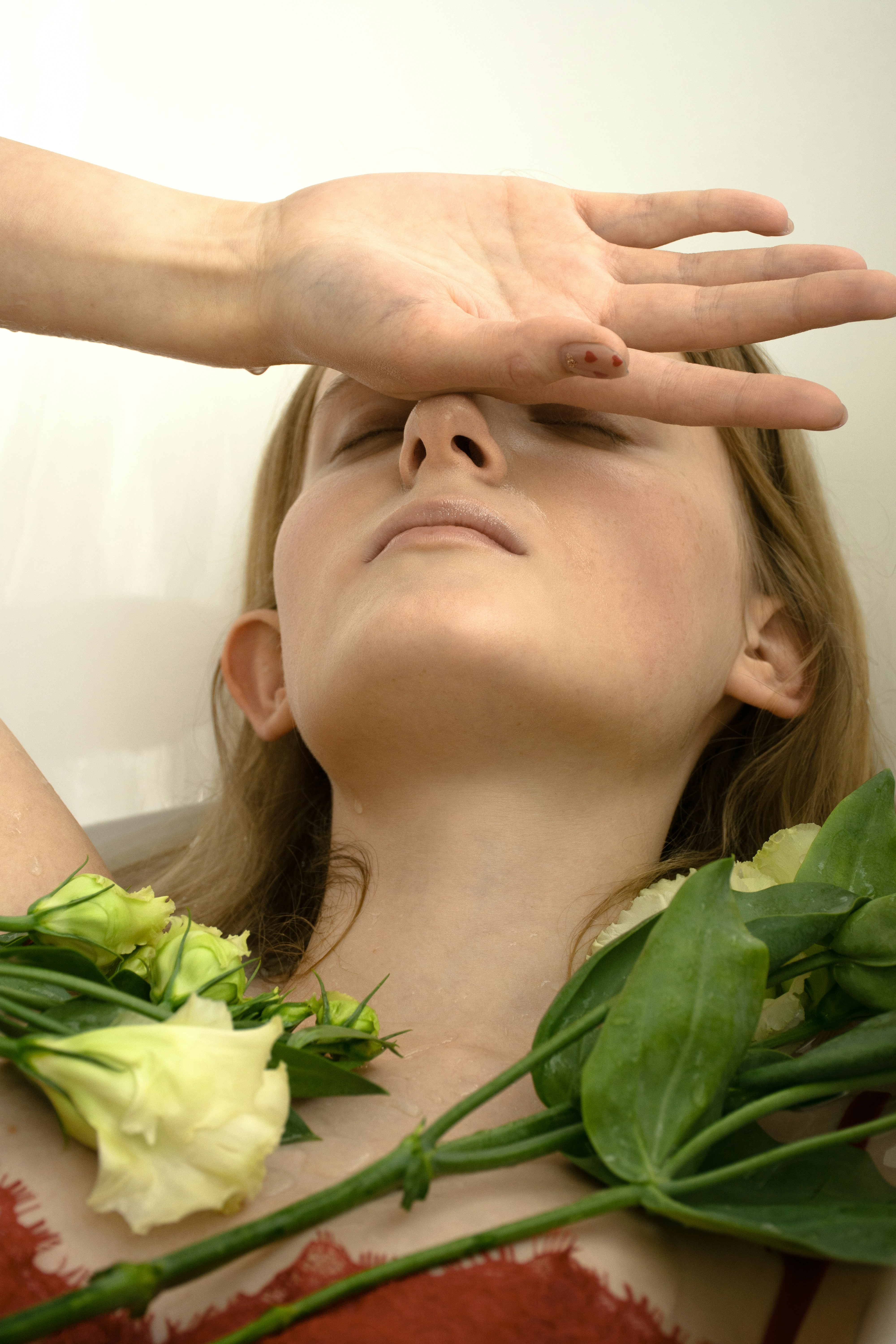 a woman in a red dress holding her hands up to her face