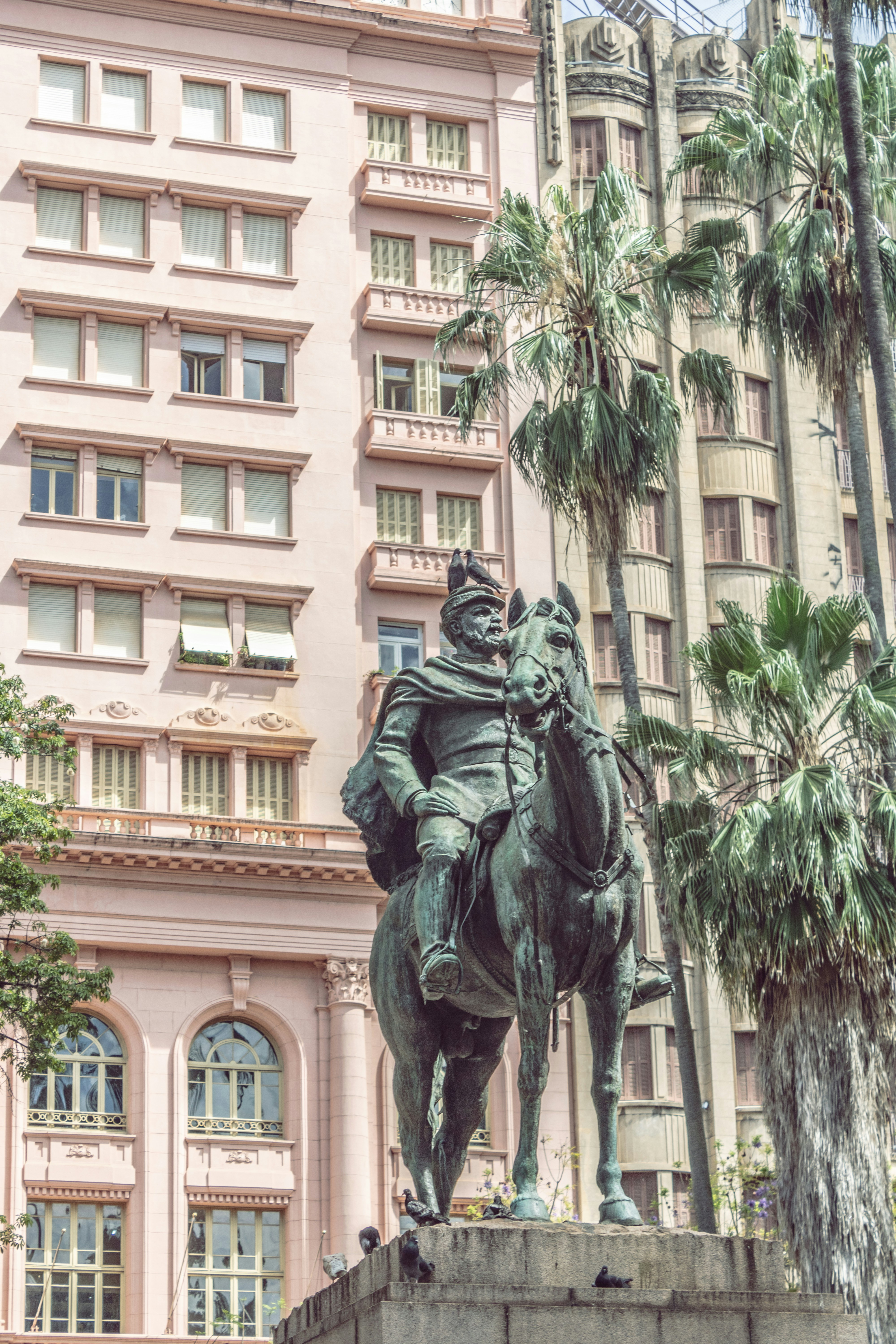 a statue of a man on a horse in front of a building
