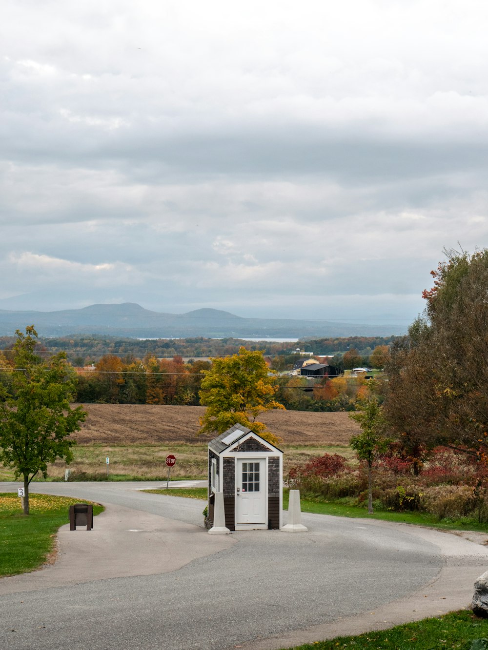 a small outhouse sitting on the side of a road