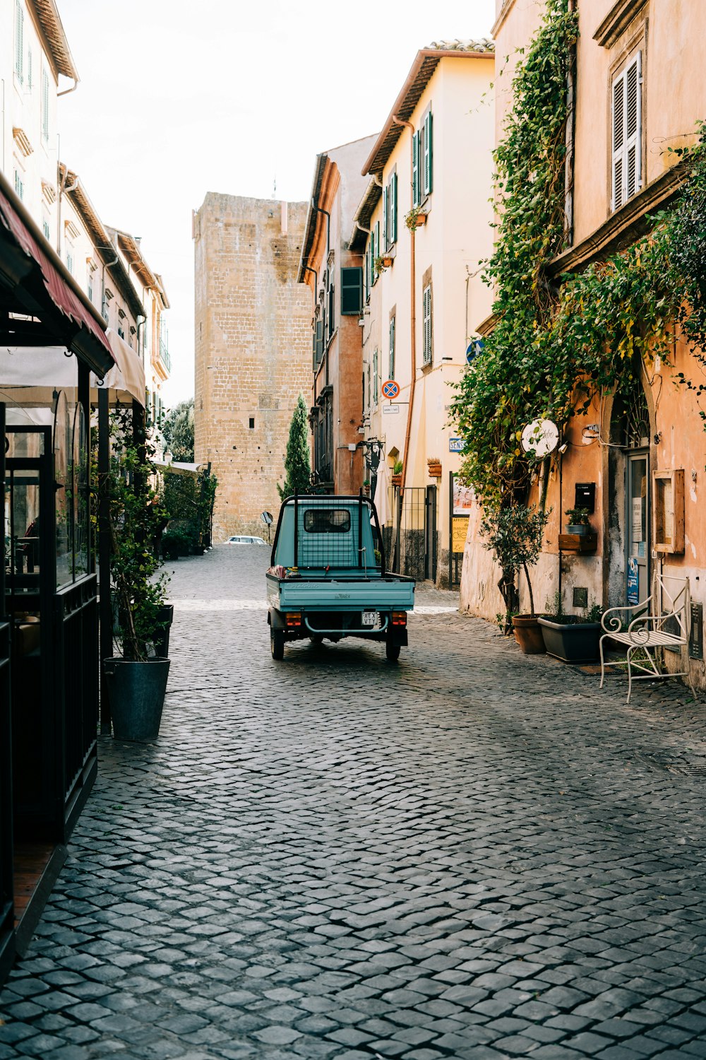 a blue truck is parked on a cobblestone street