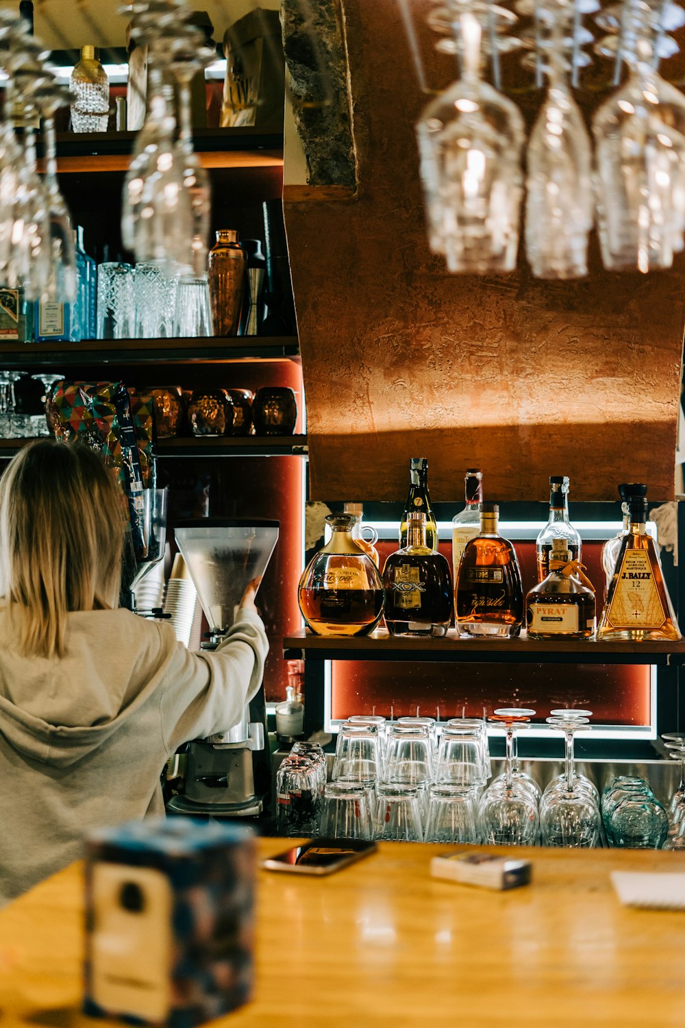 a woman behind a bar pouring a drink