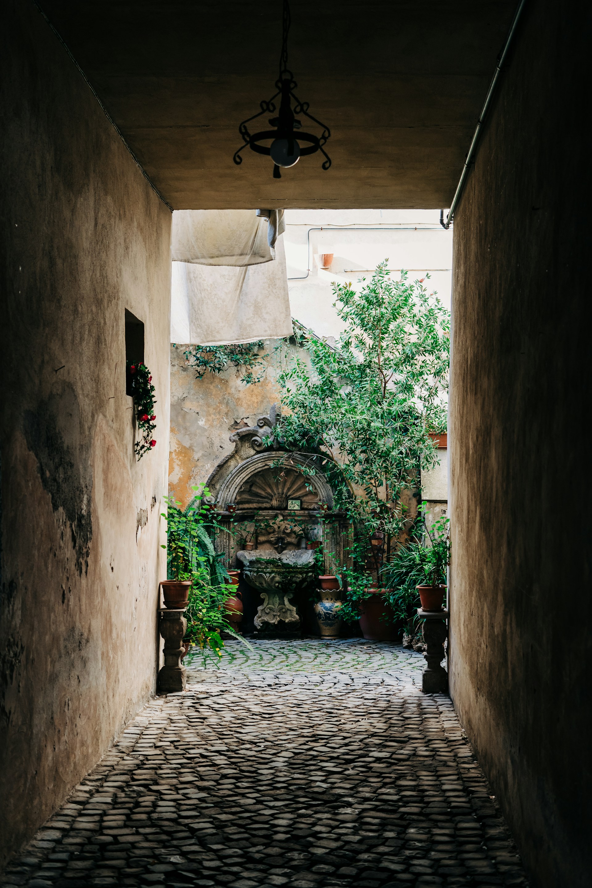 an alley way with a lamp hanging from the ceiling